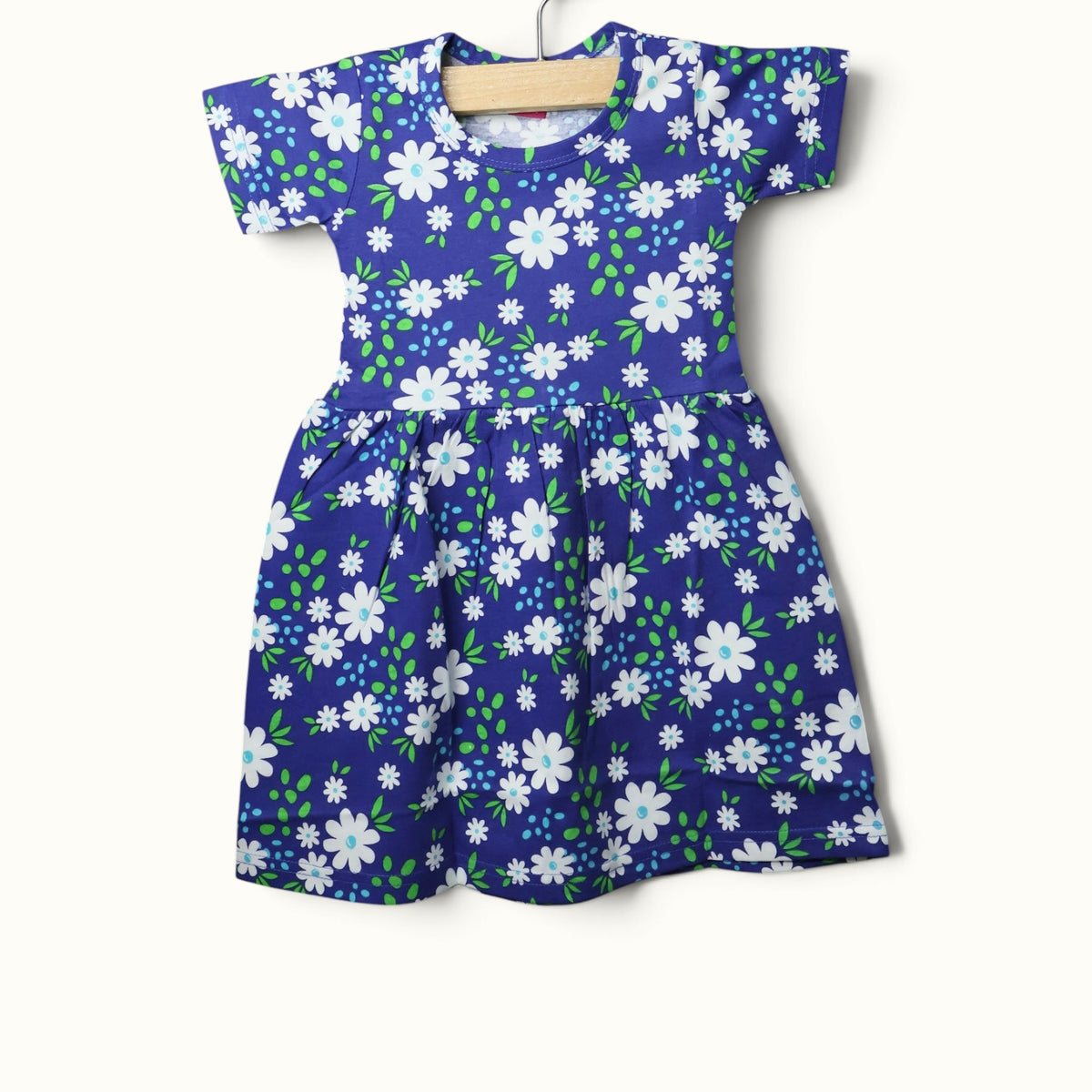 Blue baby short sleeve frock with white floral and green leaf printed design.