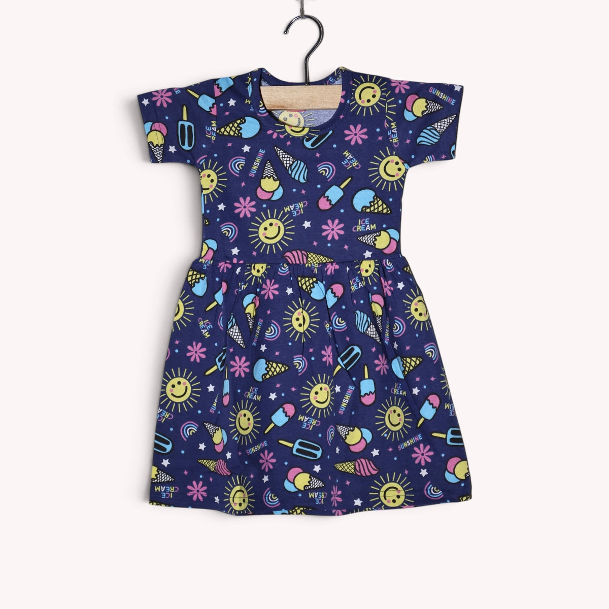Navy blue baby frock with a colorful print featuring ice creams, sunshine, rainbows, flowers and stars, with short sleeves and a gathered waist
