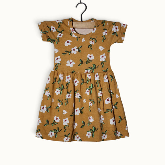 Mustard yellow baby short sleeve frock with white floral and green leaf printed design.