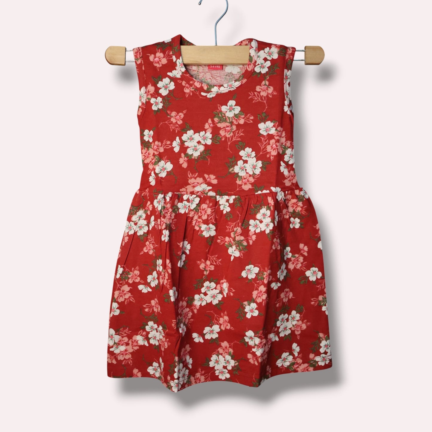 Red baby sleeveless frock with white and pink floral printed design