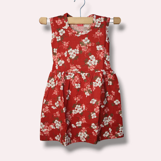 Red baby sleeveless frock with white and pink floral printed design