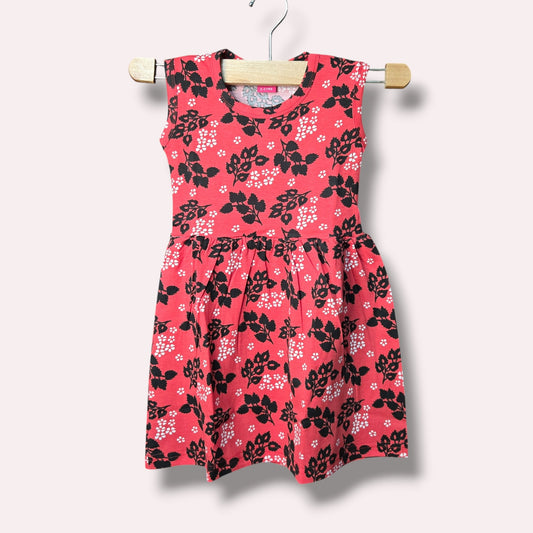 Coral pink baby sleeveless frock with black and white floral printed design