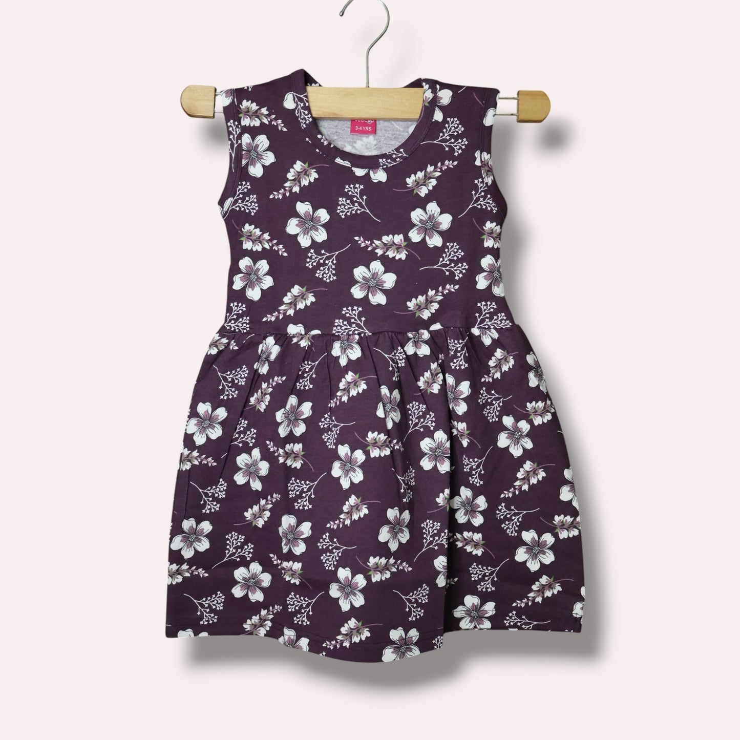 Plum purple baby girl sleeveless frock with white floral and leafy printed design