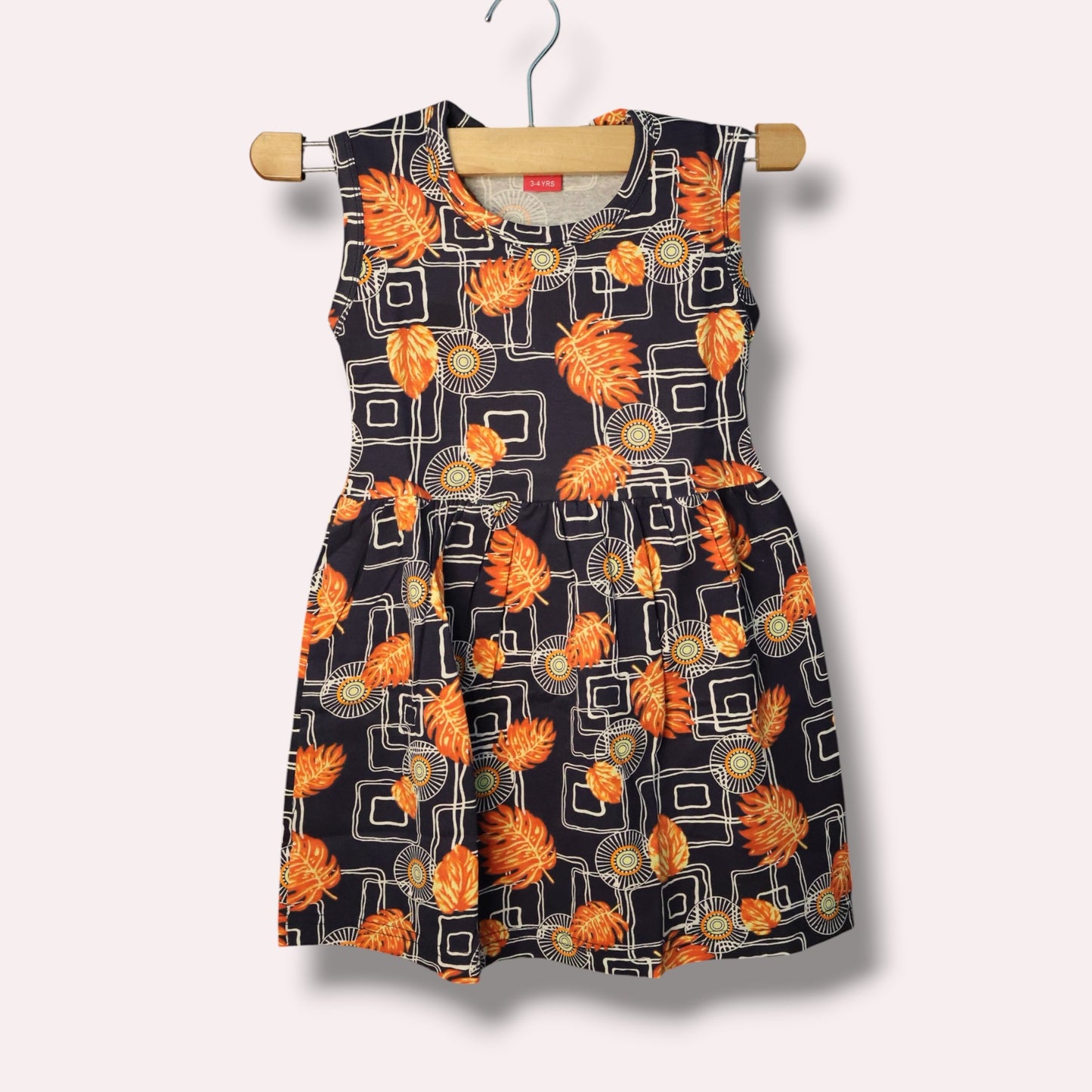 Navy baby sleeveless frock with orange leaf and geometric printed design