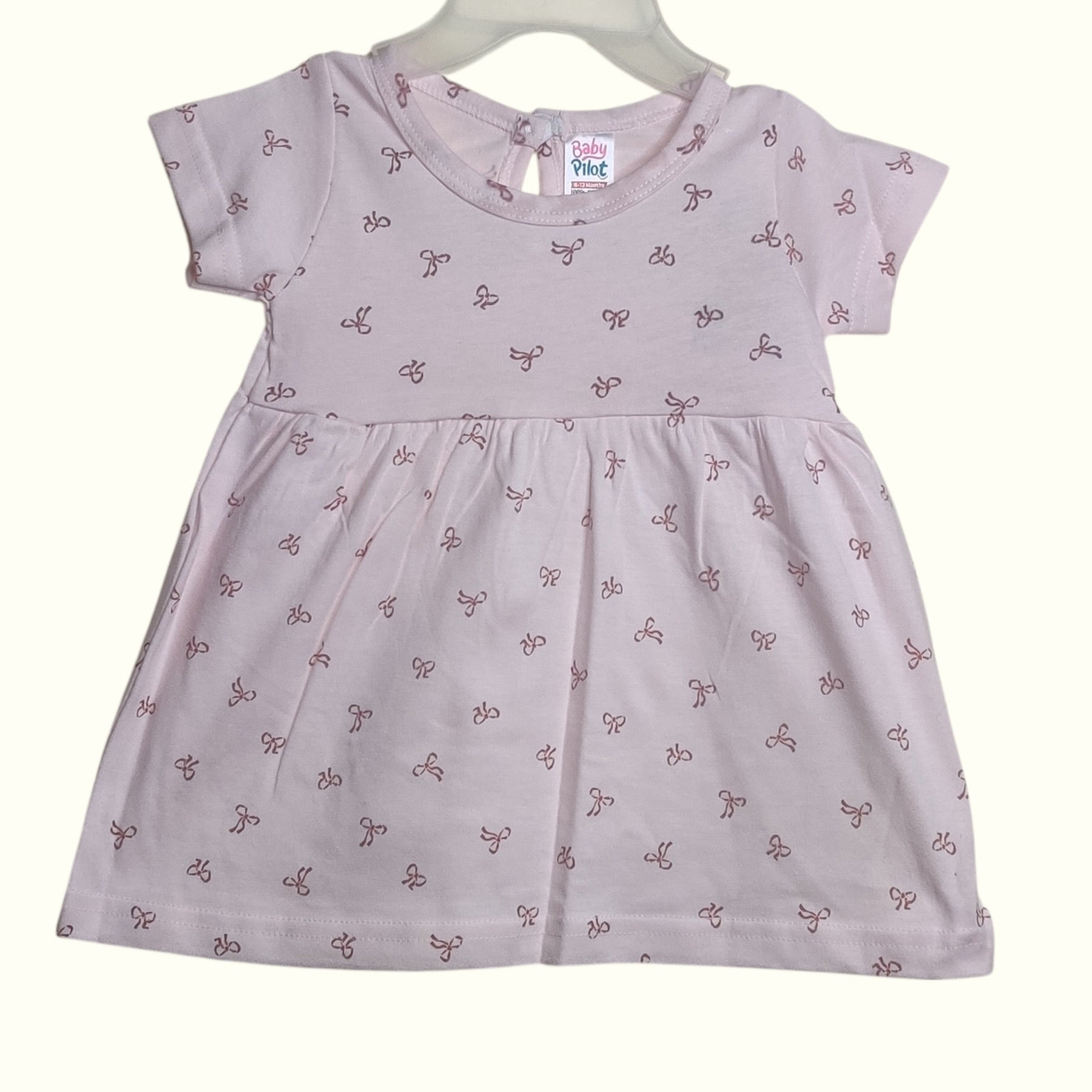 Soft blush beige baby frock with printed bow design
