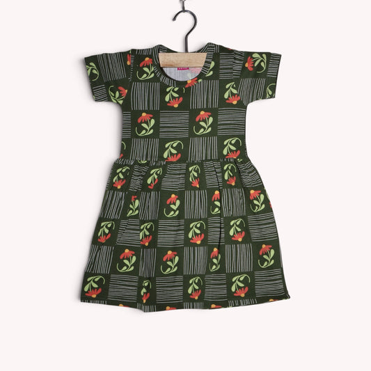 Dark green cotton baby frock featuring coral flowers, light green leaves and white stripes arranged in a geometric pattern, with short sleeves and a gathered waist.