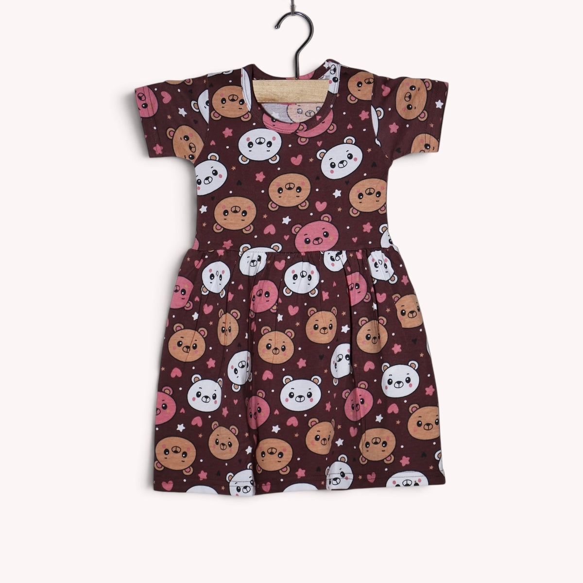 Brown baby frock with an allover teddy bear and heart print in pink, white and tan, featuring short sleeves