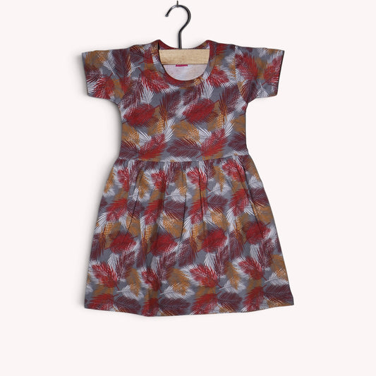Dusty grey baby frock with a tropical leaf print in brick red, maroon, mustard and white, featuring short sleeves and a gathered waist