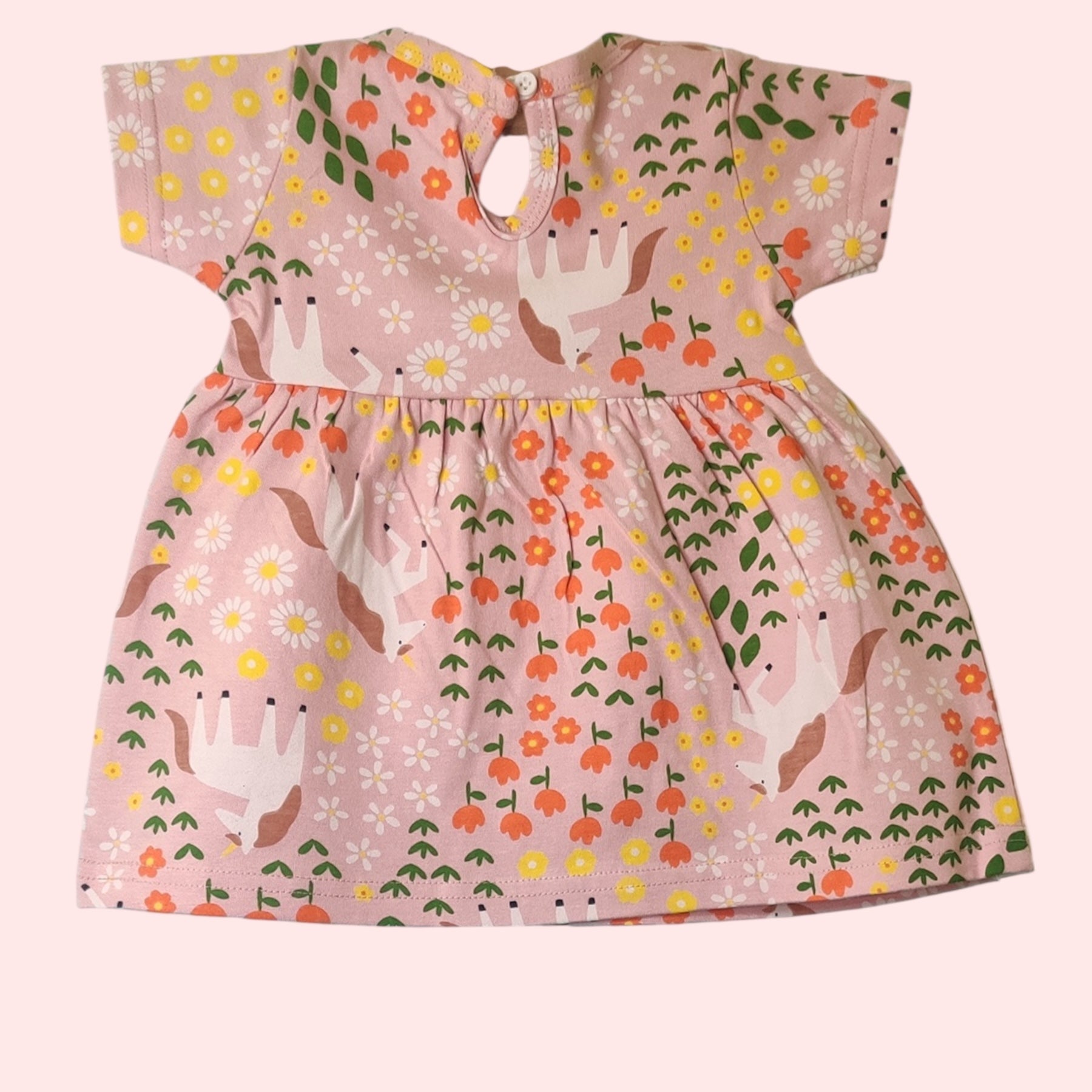 Dusty pink baby girl frock showing snap button closure