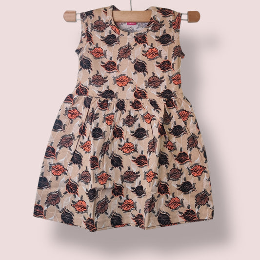 Sandy beige toddler sleeveless frock with all-over leaf print